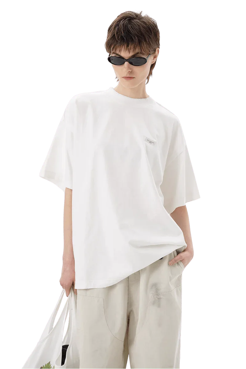 Model wearing Masonprince SS25 Tape Tee white oversized t-shirt with sunglasses and light beige pants