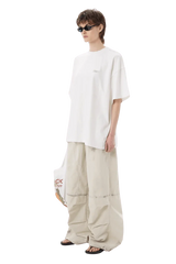 Model wearing white Masonprince SS25 Tape Tee with oversized fit and beige wide-leg pants