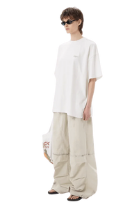 Model wearing white Masonprince SS25 Tape Tee with oversized fit and beige wide-leg pants