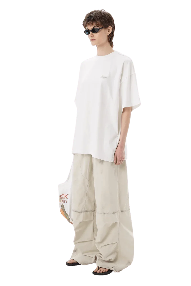 Model wearing white Masonprince SS25 Tape Tee with oversized fit and beige wide-leg pants