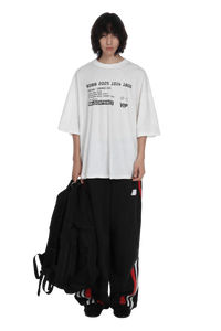 Masonprince SS25 VIP Tee white oversized shirt with black printed text worn by model
