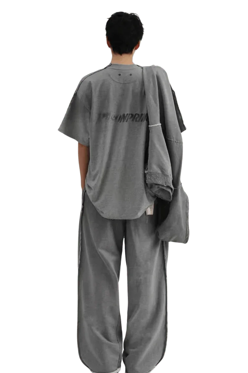 Back view of a person wearing a gray Masonprince Tag Drop Tee with matching wide-leg pants and jacket
