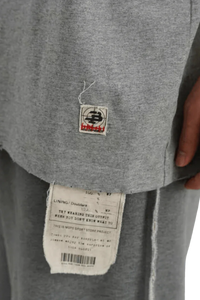 Close-up of gray Masonprince Tag Drop Tee showing fabric texture and signature tags on hem and lining