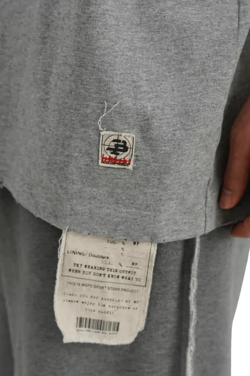 Close-up of gray Masonprince Tag Drop Tee showing fabric texture and signature tags on hem and lining