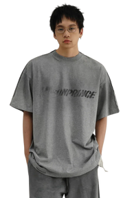 Masonprince Tag Drop Tee in gray worn by model with glasses featuring bold logo print on front