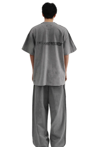 Back view of a person wearing Masonprince Tag Drop Tee in gray with matching wide-leg pants