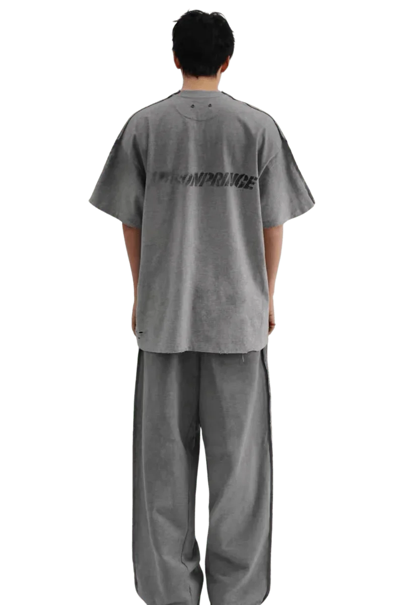 Back view of a person wearing Masonprince Tag Drop Tee in gray with matching wide-leg pants