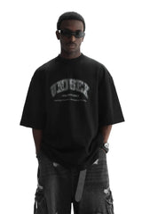 Masonprince unisex logo tee in black worn by model with sunglasses and ripped jeans