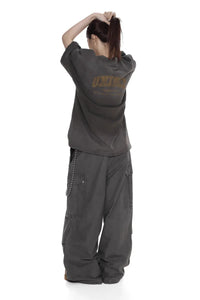 Masonprince unisex logo tee in dark gray worn by model seen from back with casual oversized pants