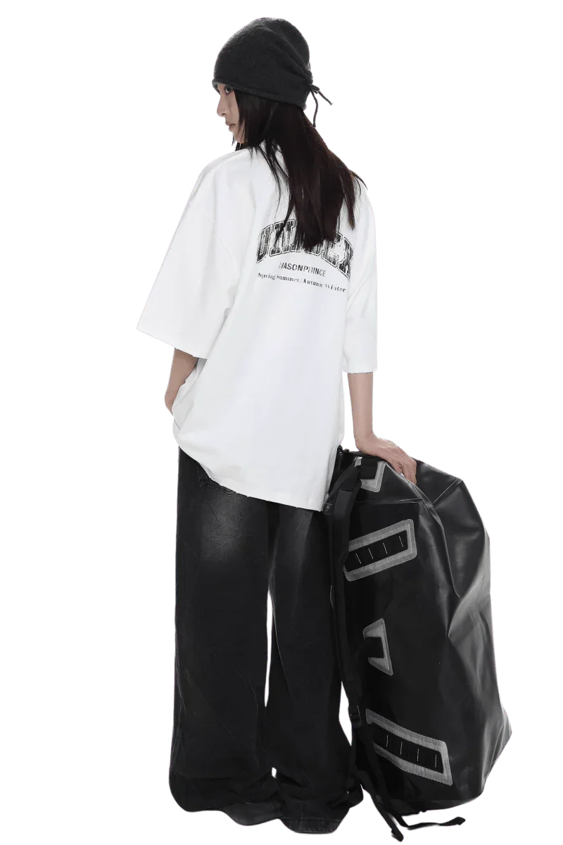 Masonprince unisex logo tee worn by model with black beanie and wide black pants holding large black bag