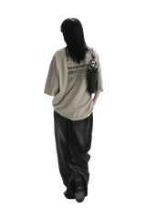Person wearing beige Masonprince WashTag Tee with graphic print on back and black pants