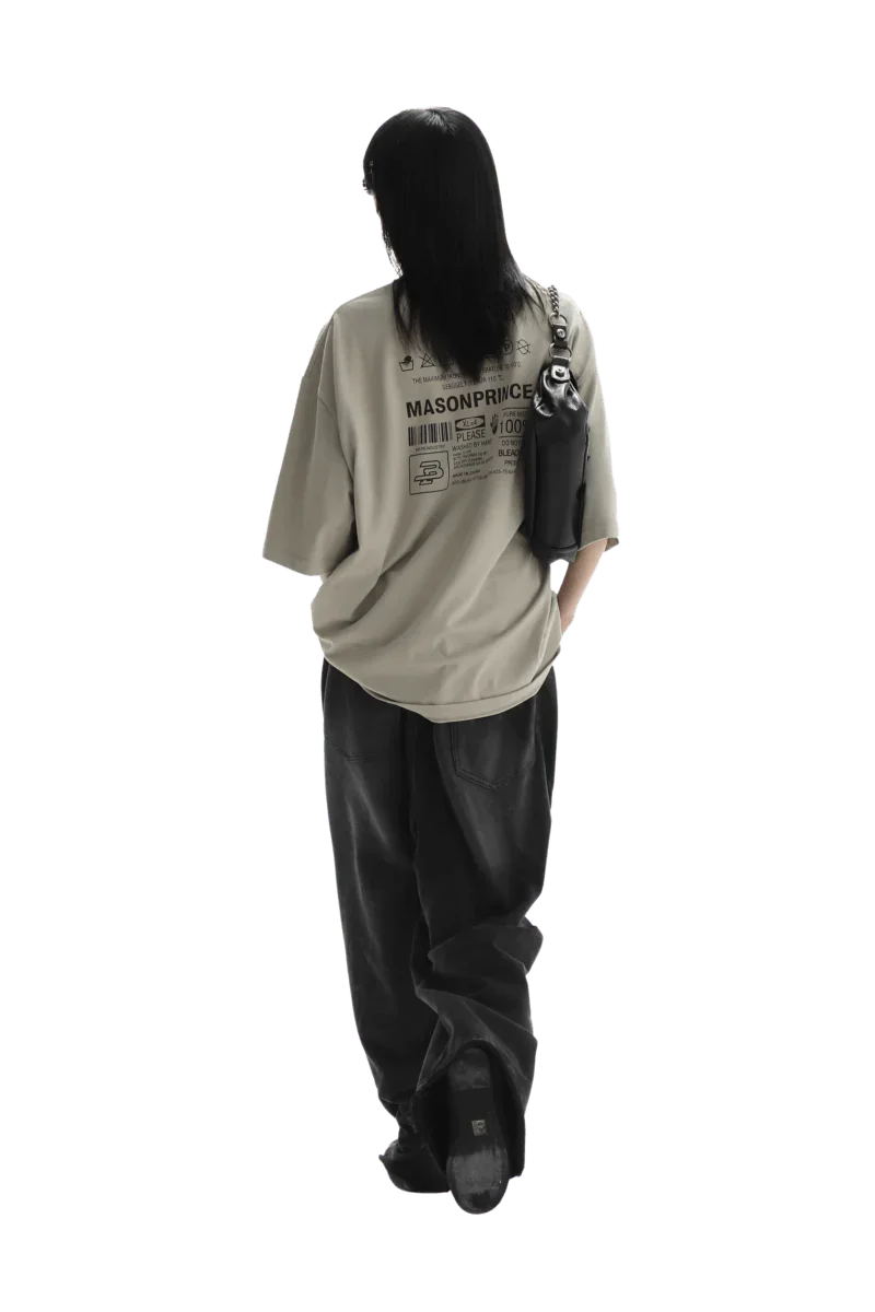 Person wearing beige Masonprince WashTag Tee with graphic print on back and black pants