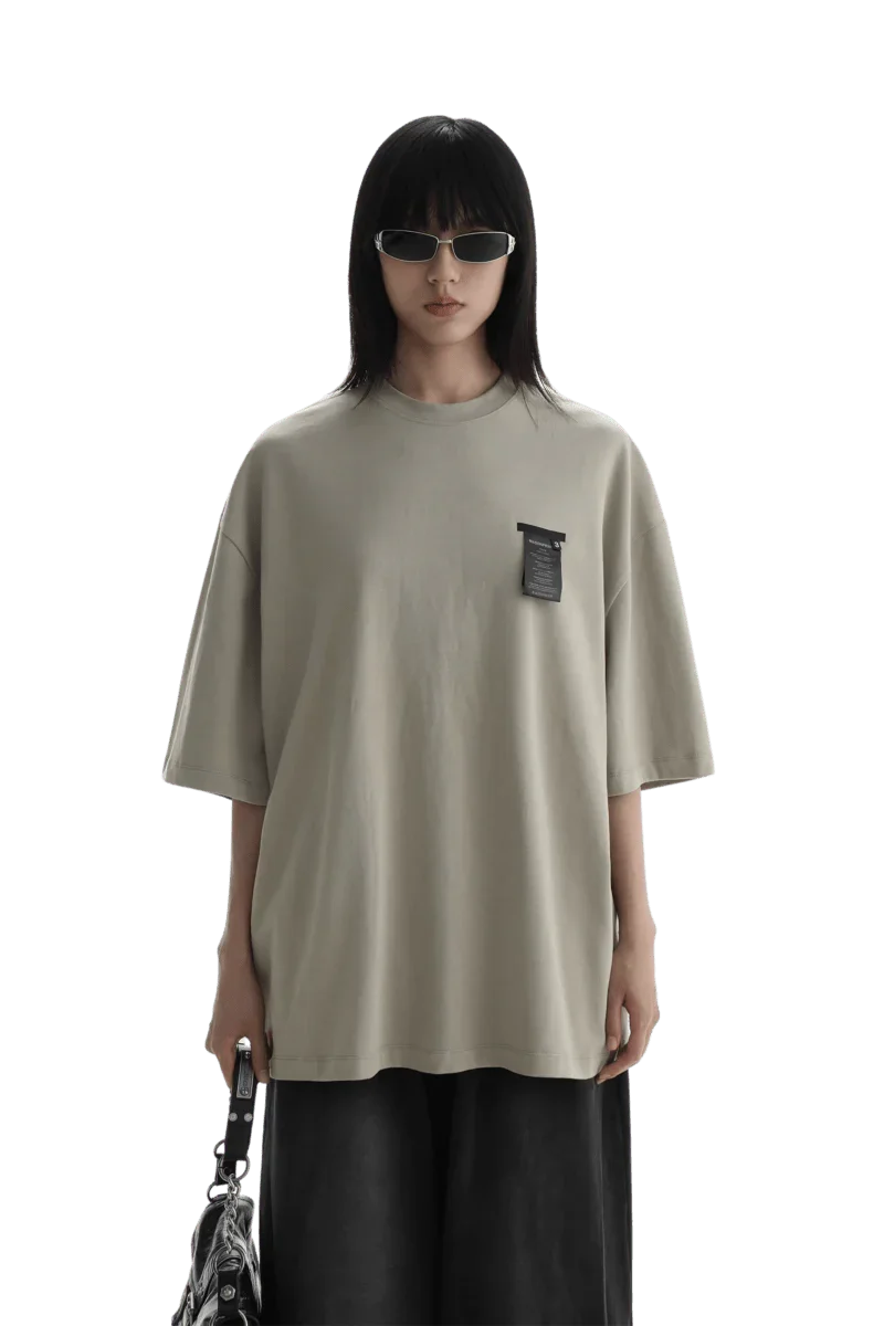 Masonprince WashTag Tee oversized beige shirt with black wash tag detail worn by model with sunglasses