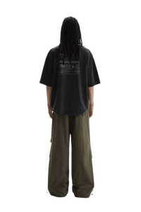 Back view of a person wearing Masonprince WashTag Tee black oversized t-shirt with printed wash tags