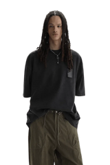 Model wearing black Masonprince WashTag Tee with relaxed fit and olive green pants on black background