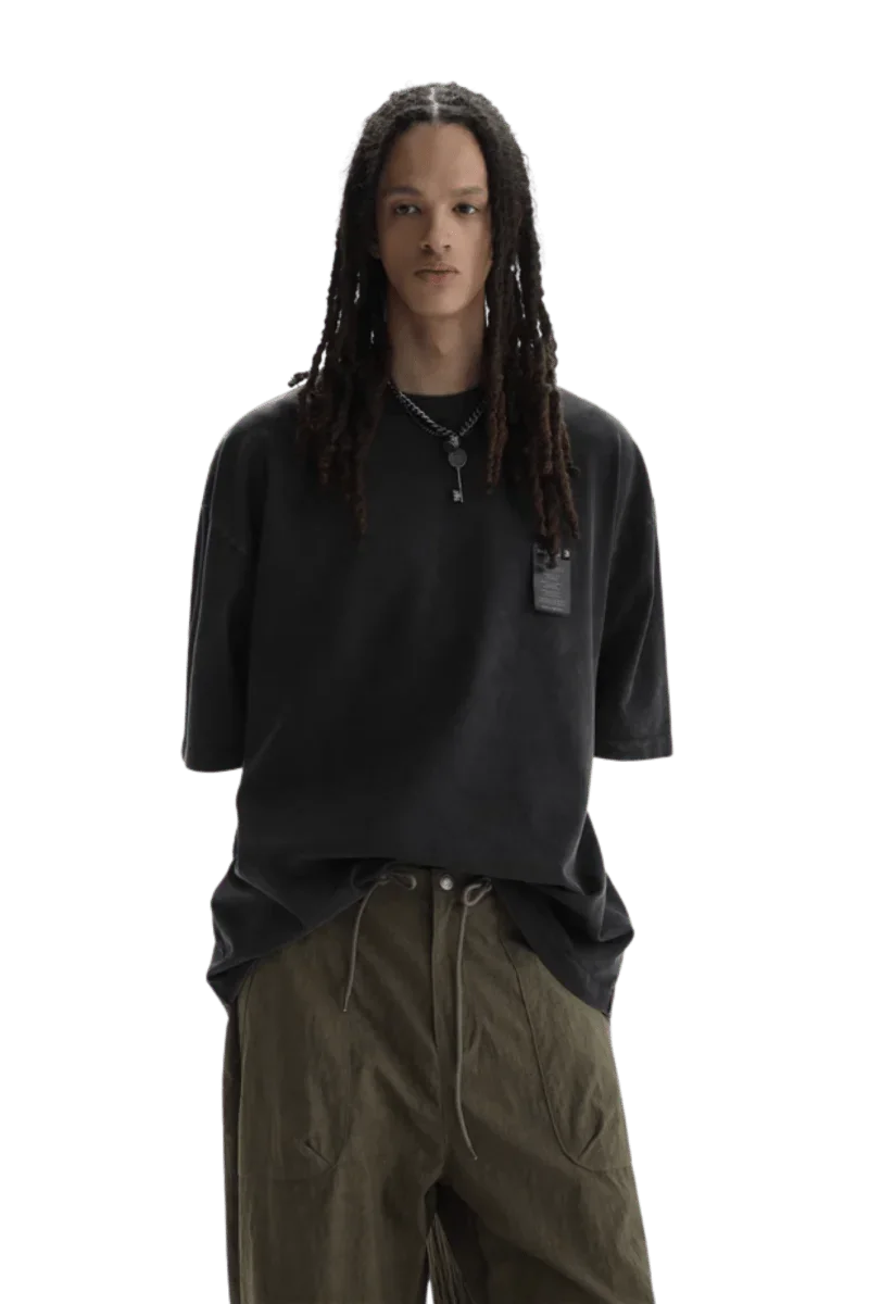 Model wearing black Masonprince WashTag Tee with relaxed fit and olive green pants on black background