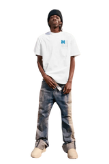 Model wearing the MEDM Badge Tee in white with blue logo, paired with distressed jeans.