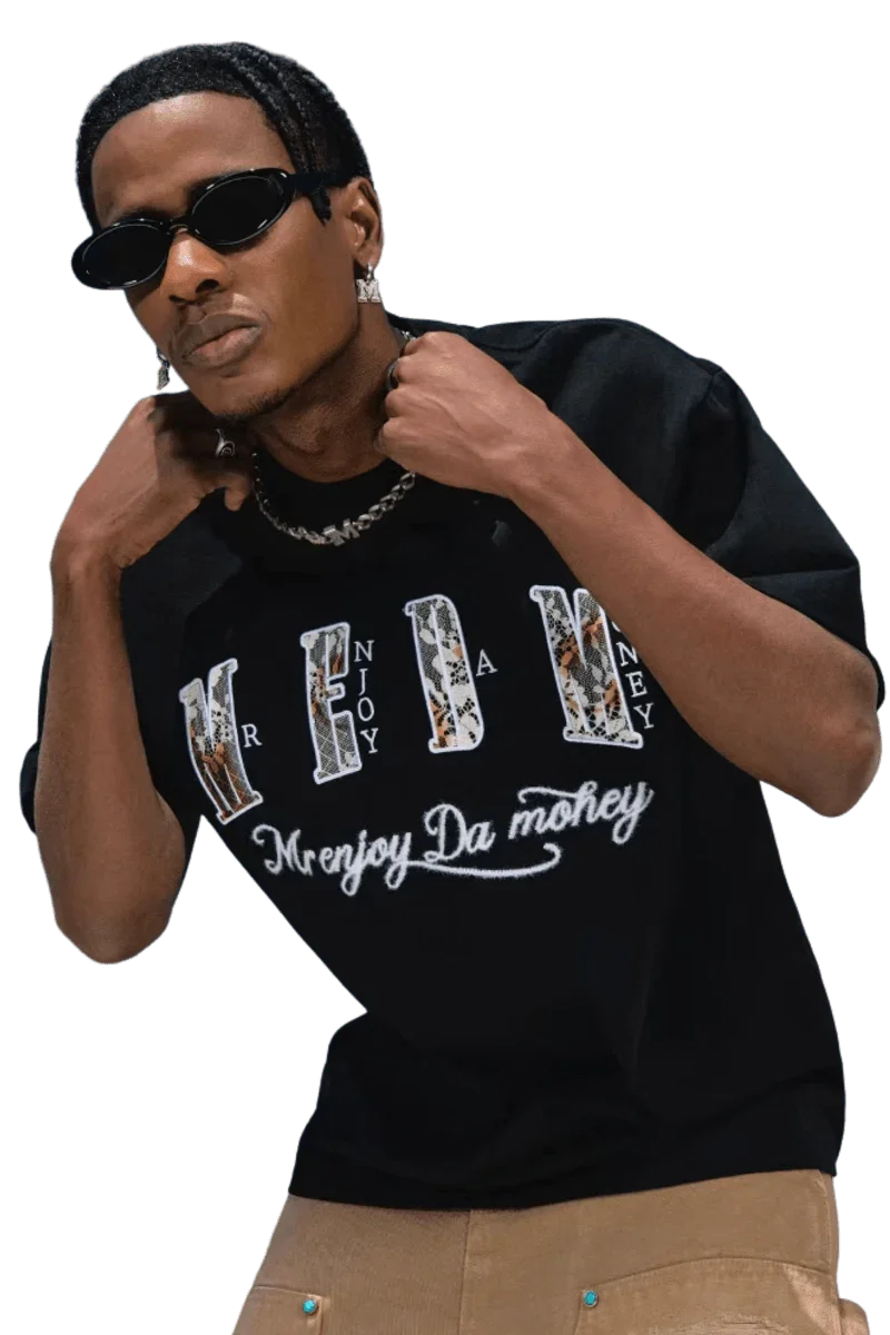 Man wearing black MEDM Burnt Laced Tee by Mr Enjoy Da Money with graphic text and stylish sunglasses