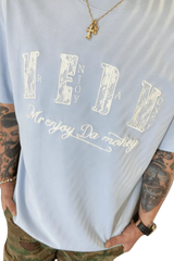 Light blue MEDM Burnt Laced Tee by Mr Enjoy Da Money with bold white graphic text worn with accessories