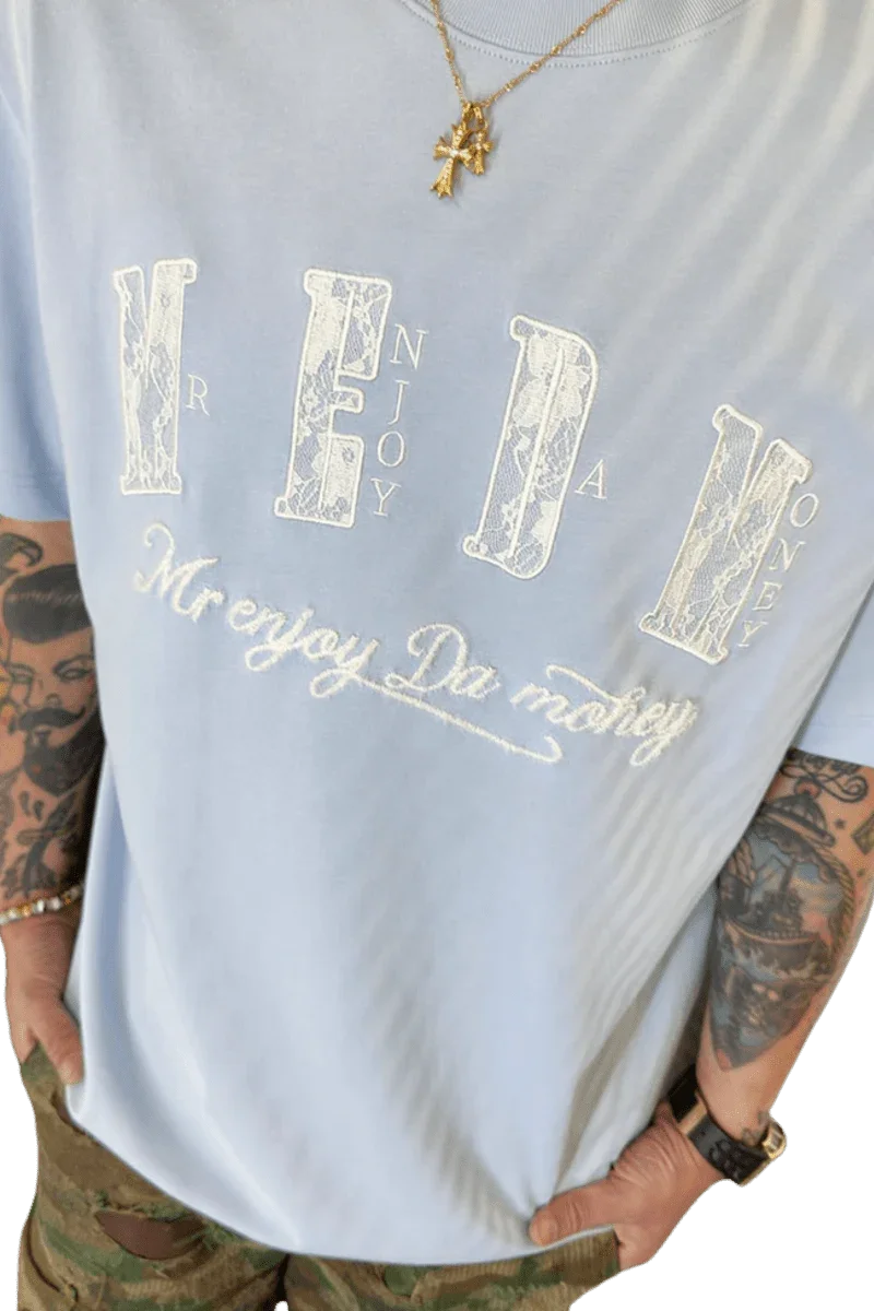 Light blue MEDM Burnt Laced Tee by Mr Enjoy Da Money with bold white graphic text worn with accessories