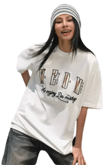 Young woman wearing a white MEDM Burnt Laced Tee by Mr Enjoy Da Money with black and white striped beanie