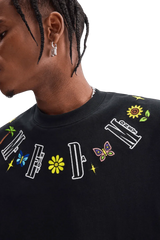 Close-up of black MEDM Butterfly Necklace Embroidery Tee by Mr Enjoy Da Money with colorful embroidered letters and butterfly design