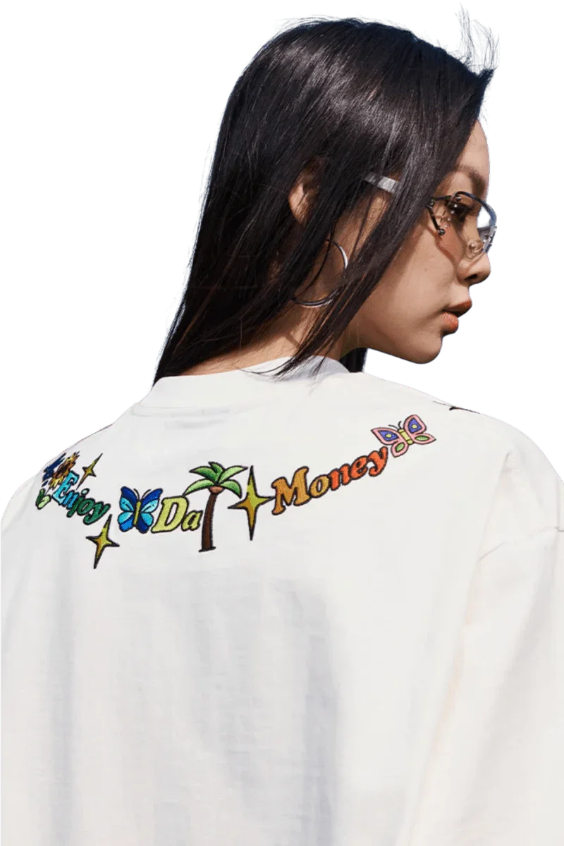 Back view of model wearing white MEDM Butterfly Necklace Embroidery Tee by Mr Enjoy Da Money with colorful embroidered design