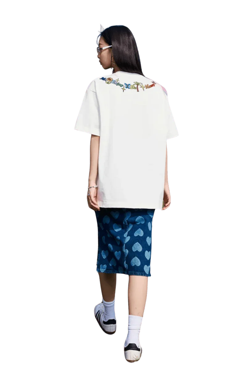 Woman wearing MEDM Butterfly Necklace Embroidery Tee white oversized shirt with colorful embroidered design on back