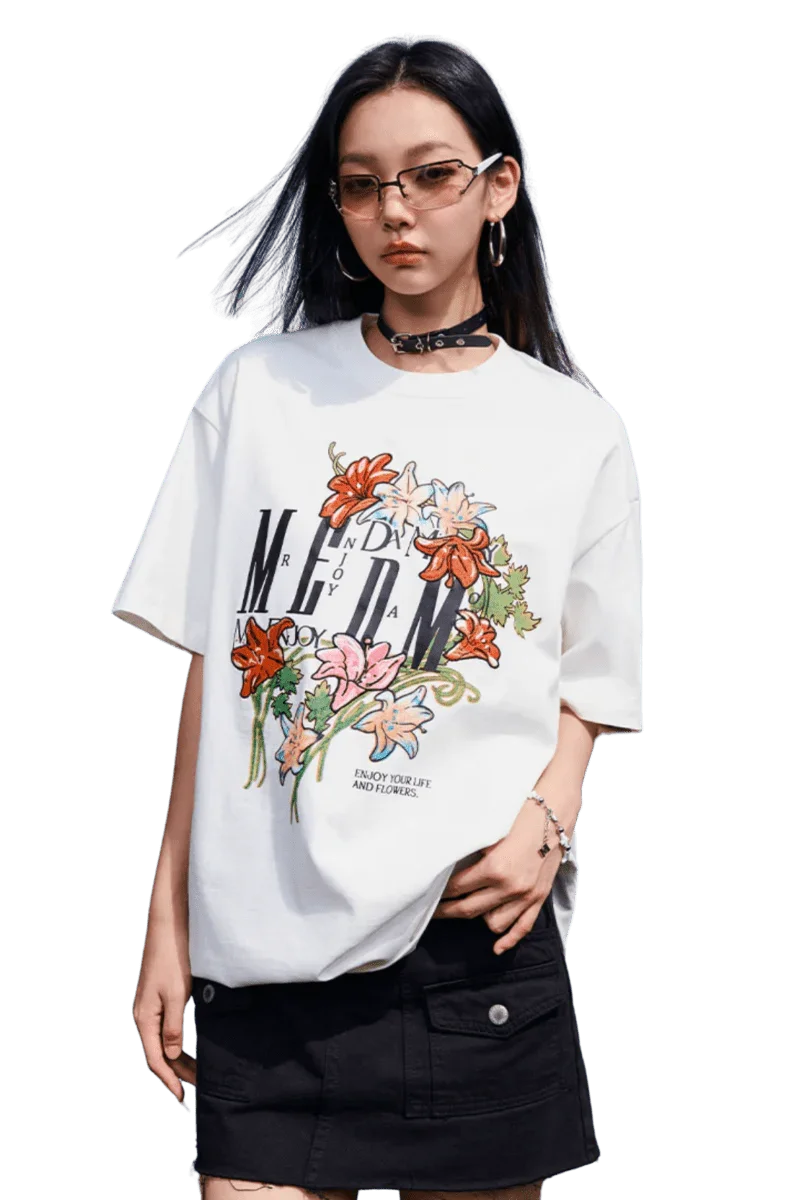 Model wearing a MEDM Curved Flower Print Tee in white with vibrant floral designs