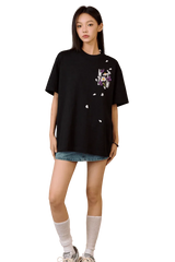 Woman wearing black MEDM Falling Petals Embroidery Tee with floral design paired with denim shorts