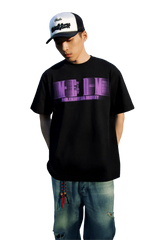 Model wearing black MEDM Phantom Contrast Tee with purple graphic and casual jeans