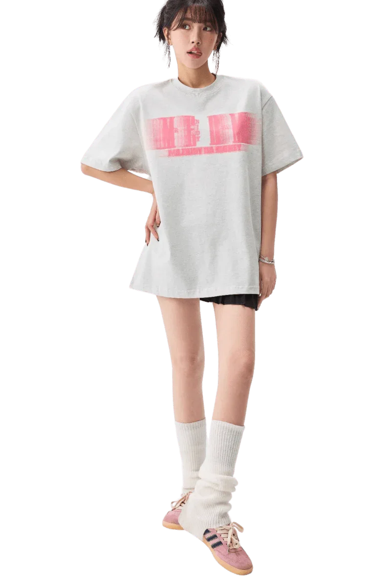 Woman wearing white MEDM Phantom Contrast Tee with pink graphic and casual outfit