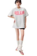 Woman wearing white MEDM Phantom Contrast Tee with pink graphic and casual outfit