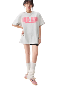 Woman wearing white MEDM Phantom Contrast Tee with pink graphic and casual outfit