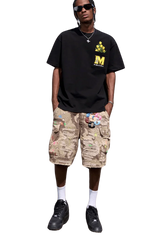 Man wearing a black MEDM Pixelated Flower Pocket Tee by Mr Enjoy Da Money with beige camo cargo shorts and black sneakers