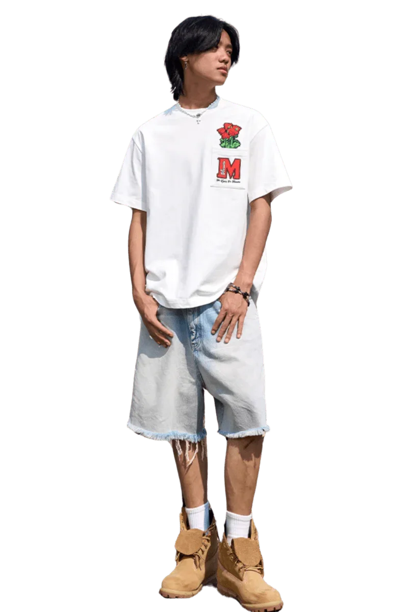 Young man wearing MEDM Pixelated Flower Pocket Tee in white with red flower and M logo