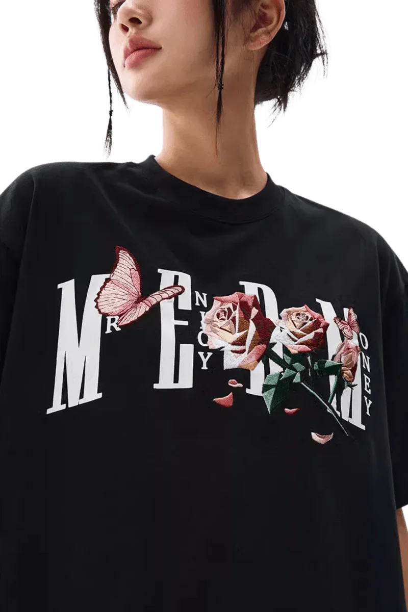 MEDM Rose Butterfly Embroidery Tee featuring bold graphics and floral design on a black background