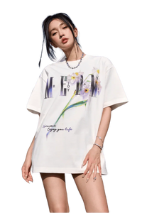 Woman wearing white MEDM Smudged Floral Tee by Mr Enjoy Da Money with floral and text design