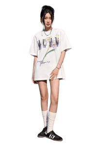 Model wearing a white MEDM Smudged Floral Tee by Mr Enjoy Da Money with artistic floral print and casual fit