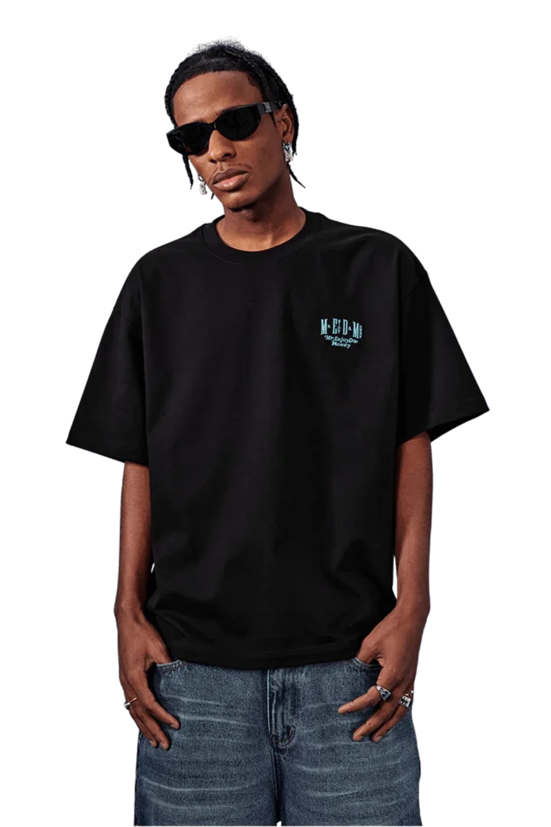 Model wearing a black MEDM SS25 Basic Embroidery Tee paired with stylish sunglasses and denim shorts
