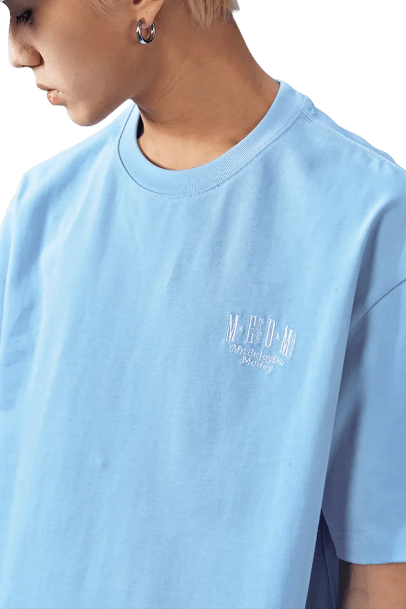 Light blue MEDM SS25 Basic Embroidery Tee designed for a relaxed fit with stylish logo detail