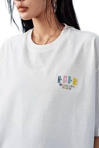 White MEDM SS25 Basic Embroidery Tee featuring colorful logo on the front for casual wear