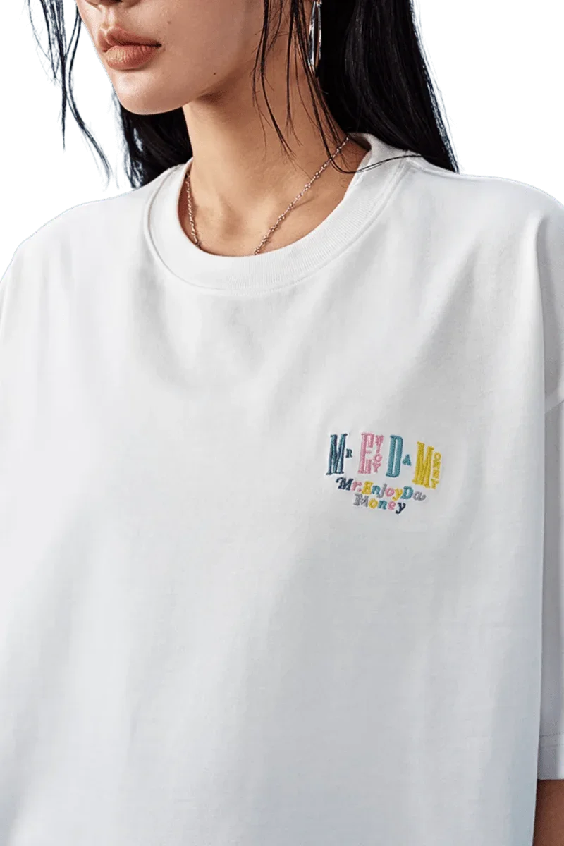 White MEDM SS25 Basic Embroidery Tee featuring colorful logo on the front for casual wear