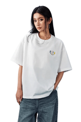 Model wearing MEDM SS25 Basic Embroidery Tee in white with loose fit and stylish design
