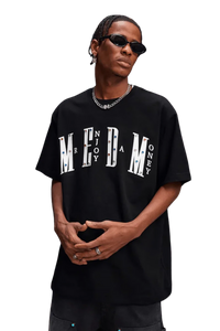 Model wearing MEDM SS25 Basic Gem Series Tee in black with bold logo design for street fashion enthusiasts