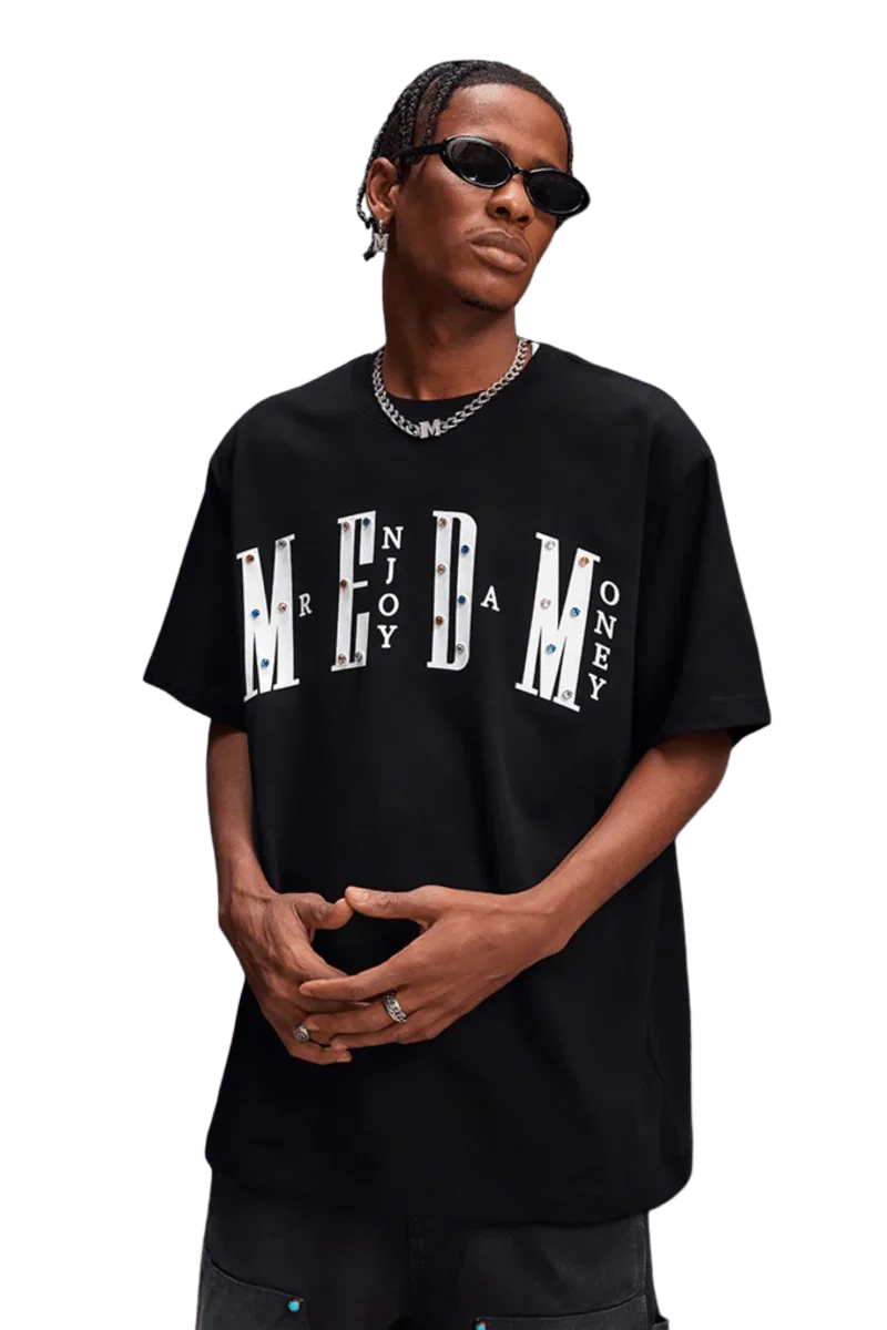 Model wearing MEDM SS25 Basic Gem Series Tee in black with bold logo design for street fashion enthusiasts