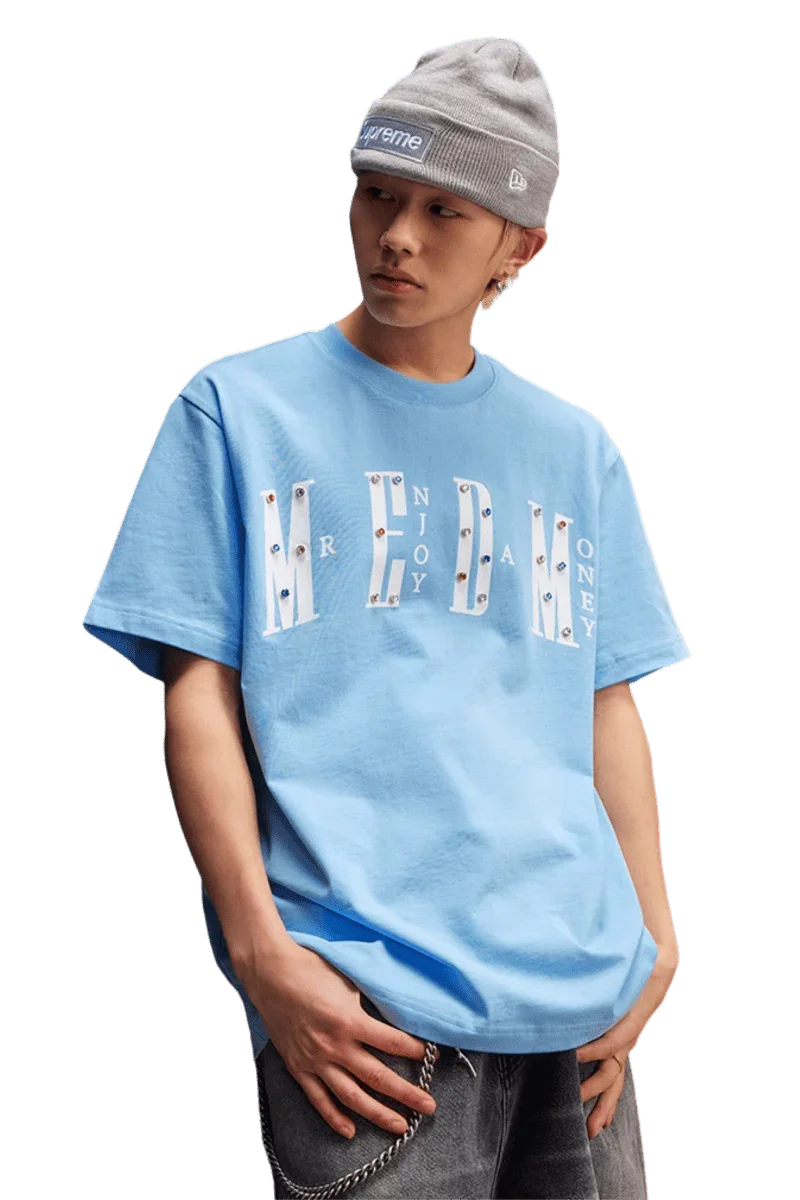 Model wearing the MEDM SS25 Basic Gem Series Tee in light blue with bold graphic design