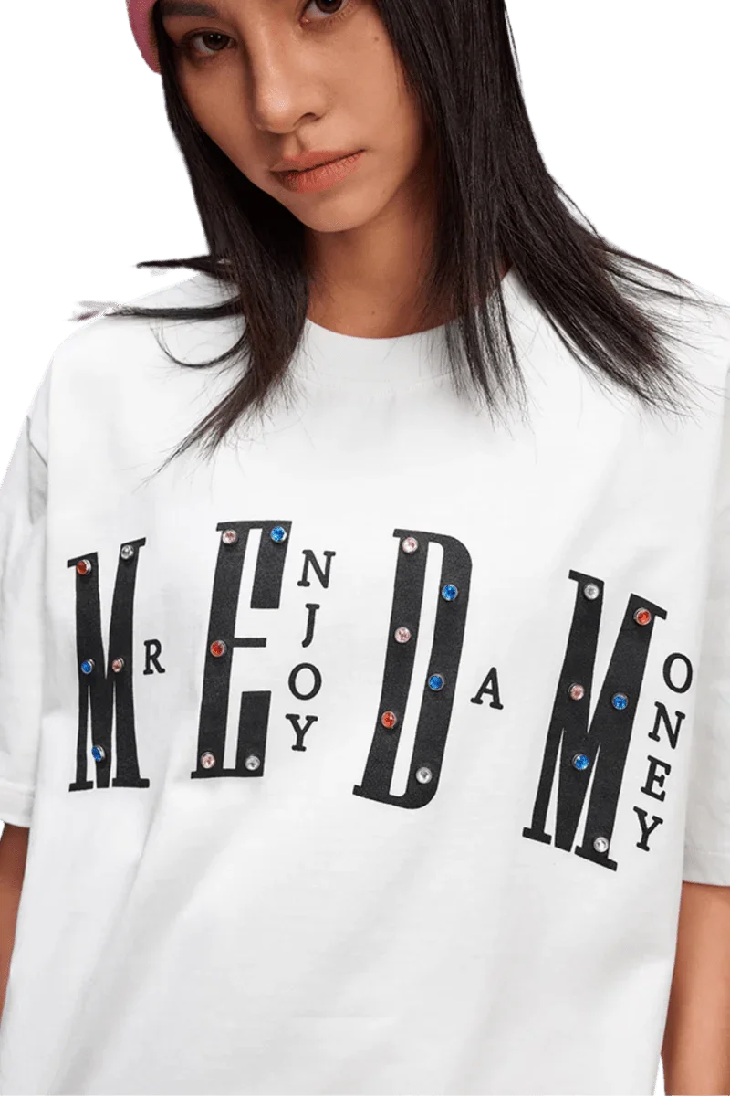 MEDM SS25 Basic Gem Series Tee featuring bold lettering and colorful embellishments on a white background