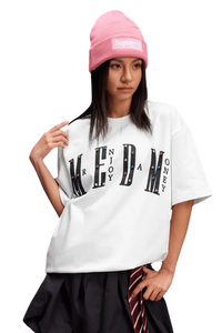 Model wearing a white MEDM SS25 Basic Gem Series Tee paired with a pink beanie and stylish skirt