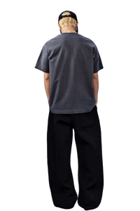 Back view of a gray MEDM SS25 Basic Logo Washed Tee styled with relaxed black pants